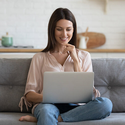Smiling young woman browsing internet | Howmar Carpet Inc